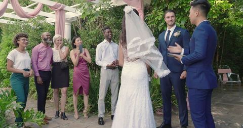 Outdoor wedding ceremony with friends celebrating newlyweds