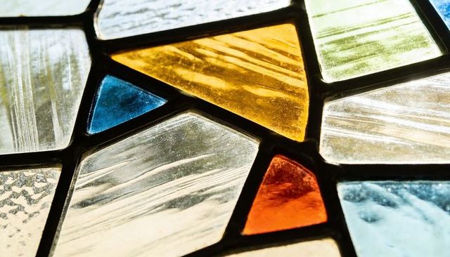 Glowing stained glass mosaic panel showing rippled textures, lead came, amber and cobalt