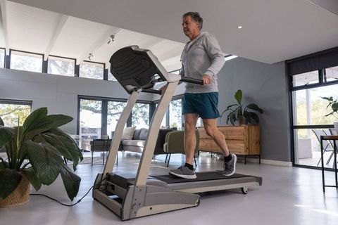 Senior Man Exercising on Treadmill in Contemporary Living Space