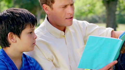 Father and Son Bonding While Reading in Green Park