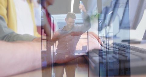Male coworker raising arm celebrating teamwork in modern coworking space double exposure