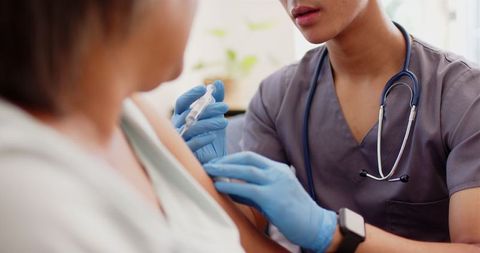 Nurse Administering Vaccine to Senior Woman in Healthcare Setting
