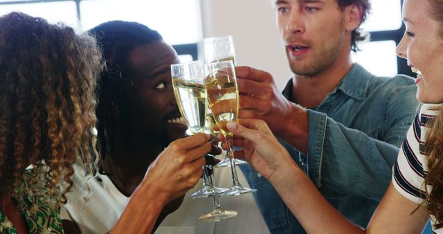 A diverse group of young adults is toasting with champagne glasses, with copy space - Download Free Stock Photos Pikwizard.com