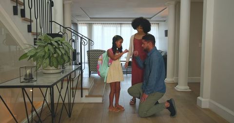 Father Giving Daughter Fist Bump in Modern Home with Smiling Mother