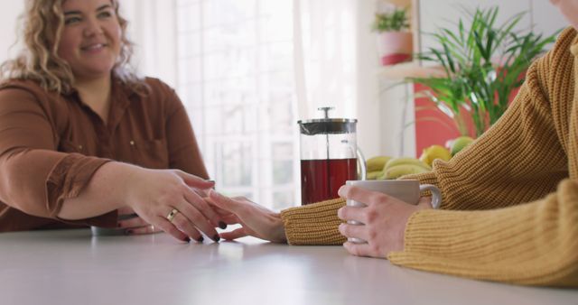 Depicts two friends engaging in comforting conversation over a morning tea. Perfect for themes of friendship, empathy, support, and leisure time in cafe or home settings. Useful for advertisements, blog posts, and social media content related to support networks, emotional well-being, and relaxation.