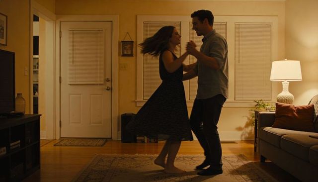 Couple dancing barefoot on living room rug warm evening romance intimate home moment cozy