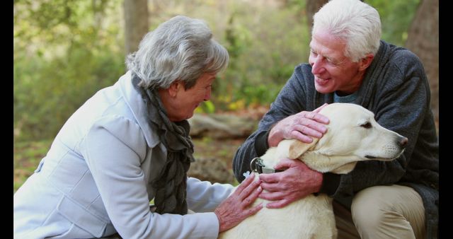 A senior Caucasian couple enjoys a moment with their pet dog in a serene outdoor setting, with copy space. Their affectionate interaction with the animal reflects a warm companionship and the joy pets bring into people's lives.