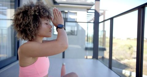 Serene Woman Meditating on Sunny Balcony During Yoga Practice