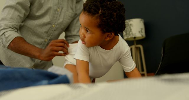 Father Dressing Young Child in Cozy Modern Bedroom Setting - Download Free Stock Images Pikwizard.com