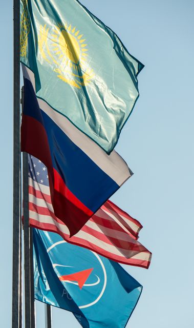 The flags of Kazakhstan, Russia, The United States, and the Russian Federal Space Agency (Roscosmos) are seen flying at teh launch pad after the Soyuz TMA-16M spacecraft was rolled out by train at the Baikonur Cosmodrome, Kazakhstan, Wednesday, March 25, 2015. NASA Astronaut Scott Kelly, and Russian Cosmonauts Mikhail Kornienko, and Gennady Padalka of the Russian Federal Space Agency (Roscosmos) are scheduled to launch to the International Space Station in the Soyuz TMA-16M spacecraft from the Baikonur Cosmodrome in Kazakhstan March 28, Kazakh time (March 27 Eastern time.) As the one-year crew, Kelly and Kornienko will return to Earth on Soyuz TMA-18M in March 2016.  Photo Credit (NASA/Bill Ingalls)