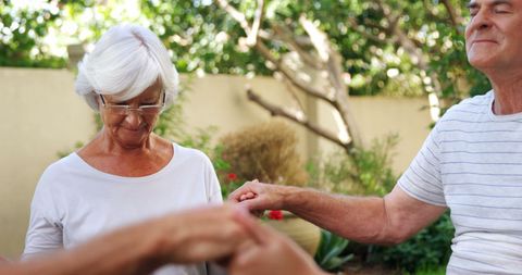 Senior Couple Enjoying Dance in Sunlit Garden