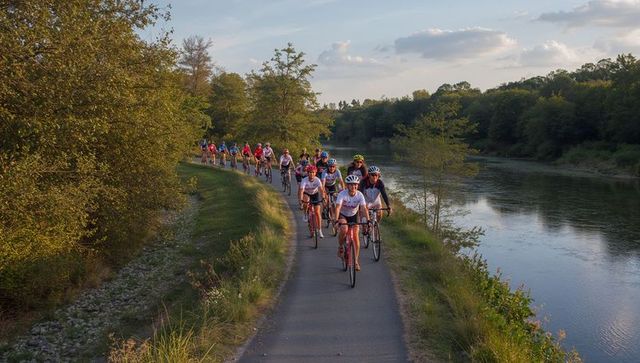 Cyclists Pedaling Along Scenic River Trail During Evening