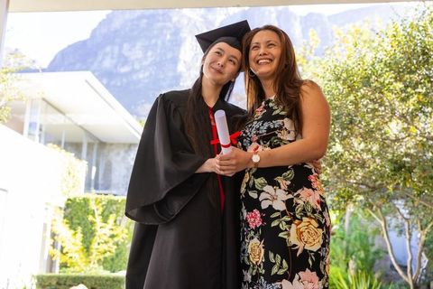 Proud Mother Celebrating Daughter's Graduation Outdoors