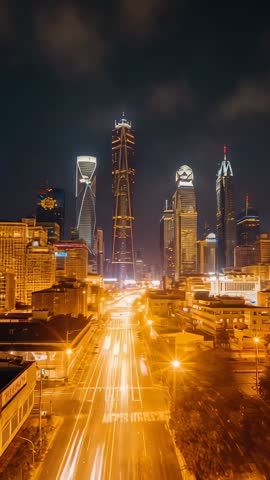 Streaming traffic passing downtown skyline at night with illuminated skyscrapers