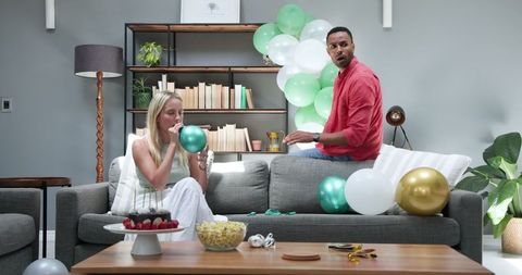 Couple Inflating Balloons for Vibrant House Party Celebration