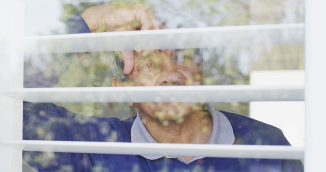 Pensive Senior Man Looking Through Window Blinds - Download Free Stock Images Pikwizard.com