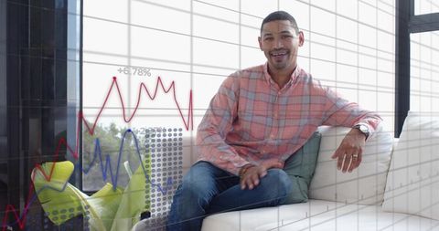 Young professional lounging with laptop and business analytics overlays in modern lounge