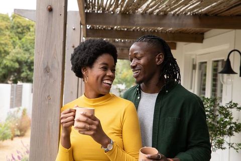 Happy Couple Enjoying Warm Drinks on Rustic Porch