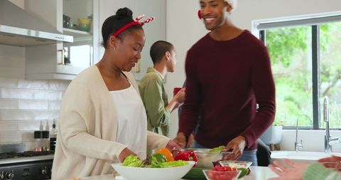 Friends preparing holiday meal together in modern kitchen