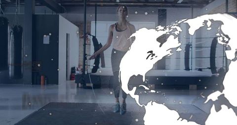 Female athlete skipping rope in industrial gym with global overlay for fitness and cardio