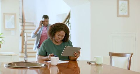 Couple Reviewing Documents with Tablet in Home Setting