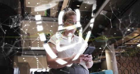 Professional Businesswoman Exploring Apps with Futuristic Interface in Modern Lobby