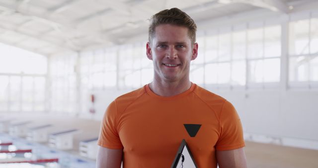 Smiling male athlete holding award in sports arena - Download Free Stock Images Pikwizard.com