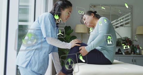 Nurse examining patient knee using augmented reality health icons for joint care
