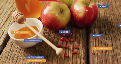 Apples, honey dipper and pomegranate seeds on rustic wood with social media badges