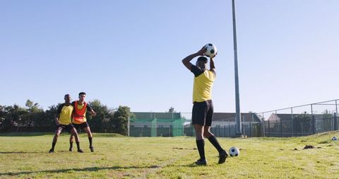 Athletic male teammates practicing football throws