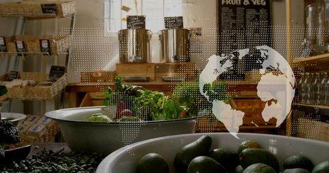 Displaying rustic market produce: avocados, mixed greens and digital globe overlay