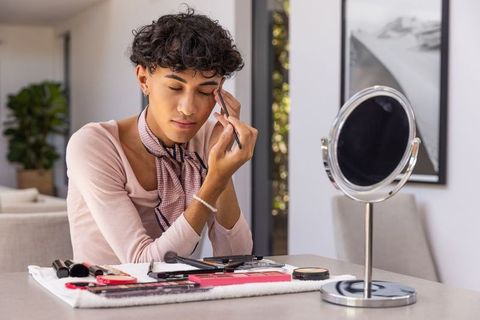 Man perfecting eyebrow make-up at home with essential tools