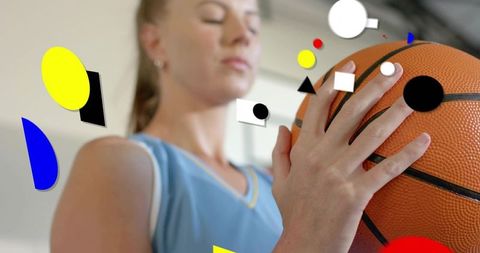 Woman basketball player gripping ball in blue jersey with geometric overlays