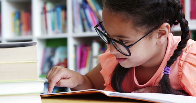 Focused Young Girl Reading in Library with Books and Glasses - Download Free Stock Images Pikwizard.com