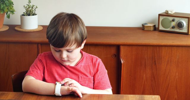 Curious Boy Checking Smartwatch Time at Home - Download Free Stock Images Pikwizard.com