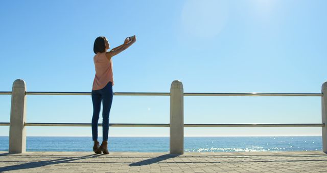 Young Woman Taking Selfie by Ocean on a Bright Day - Download Free Stock Images Pikwizard.com