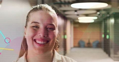 Smiling professional woman in modern office corridor with digital grid overlay confident headshot