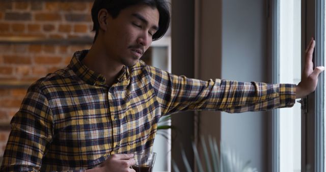 Man Sipping Coffee Looking Thoughtful by Window - Download Free Stock Images Pikwizard.com