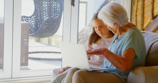Grandmother and Granddaughter Using a Laptop at Home - Download Free Stock Images Pikwizard.com