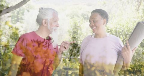 Senior diverse friends conversing in sunlit garden
