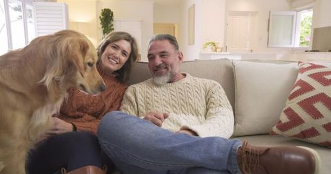 Smiling Couple with Golden Retriever in Bright Living Space
