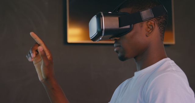 Side view of young black male executive using virtual reality headset at desk in modern office. Young black male executive gesturing 4k