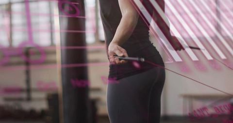 Woman adjusting jump rope through glass overlay at gym, fitness training and focus