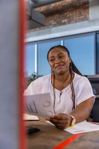 Professional Businesswoman Analyzing Charts in Modern Office Environment