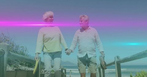 Senior Couple Enjoying Walk on Scenic Beachside Boardwalk