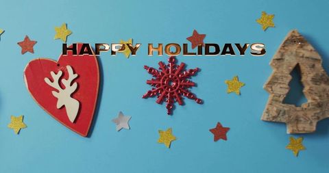 Holiday flatlay placing red reindeer heart, snowflake and wooden tree on blue backdrop
