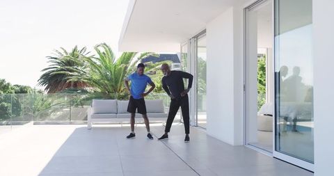 Father and Son Stretching on Sunny Terrace in Modern Setting