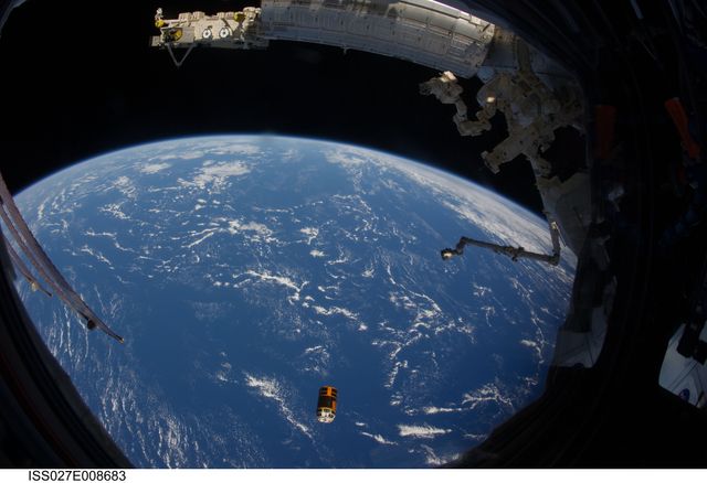 The image captures Kounotori2, an unpiloted cargo spacecraft from Japan Aerospace Exploration Agency, departing from the International Space Station, shown here filled with trash and unneeded items. The Earth is visible beneath, providing a stunning backdrop. This image can be used for space exploration articles, educational materials about the Kounotori2 mission, or illustrating the work of astronauts in space.