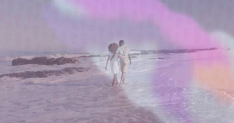 Couple Walking Hand in Hand Along Seaside at Sunset