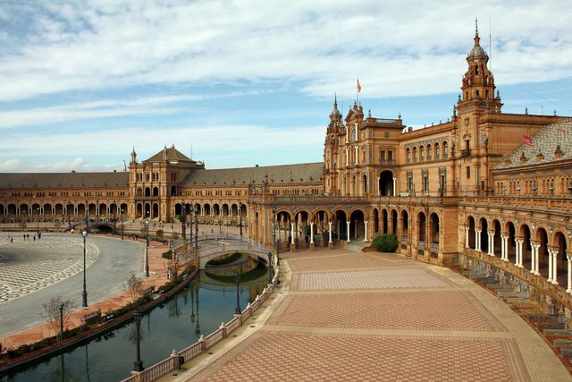Featuring the grand and detailed architecture of Plaza de España located in Seville, Spain. This iconic Spanish landmark showcases historic design elements, making it a popular destination for tourists and a significant cultural heritage site. Ideal for use in travel blogs, tourism advertisements, cultural articles, and educational materials about European or Spanish history.